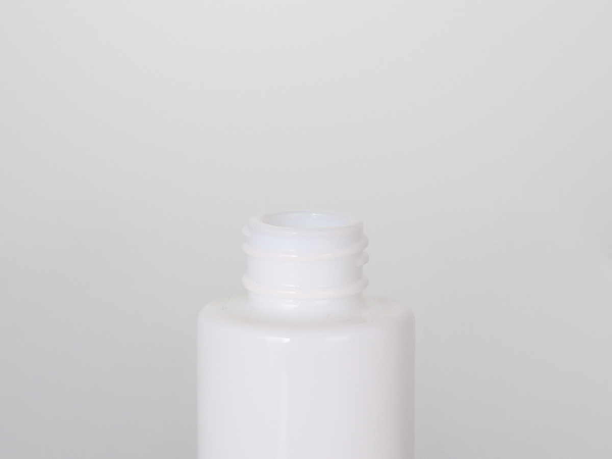 白い平らな肩の丸いローション ボトルとクリームの瓶